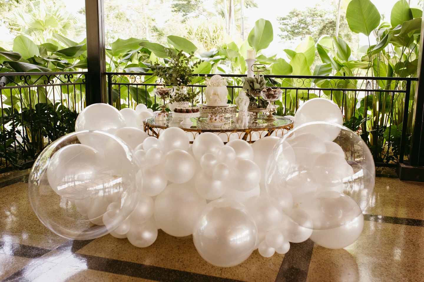 Weiße Ballon-Girlande um einen Desserttisch mit Torte